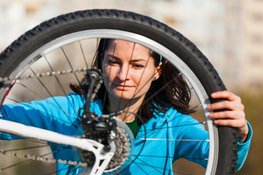 Woman trying to fix bike