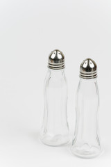 Two saltshakers on a white background