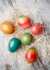 Fototapeta na wymiar Colorful easter eggs on straw