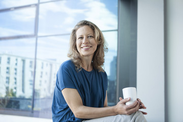Portrait of smiling mature woman at her apartment