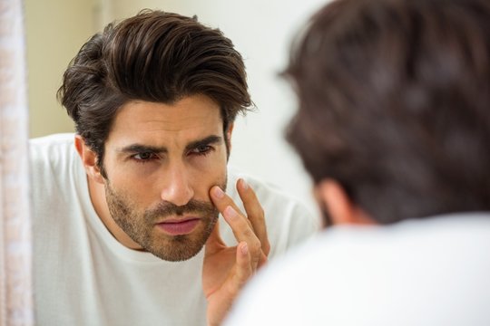 Man Checking His Skin In Bathroom