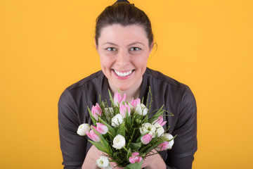 gut gelaunte frau zeigt ihren blumenstrauß