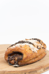 Chocolate croissant on a wooden board isolated on white