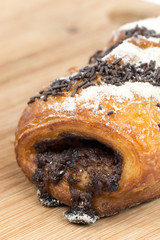 Chocolate croissant on a wooden board isolated on white