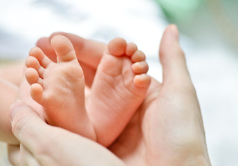 Obraz na płótnie Canvas newborn's foot in the mother hand