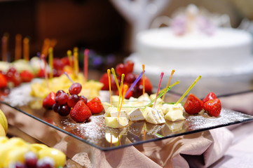 Some cheese and fresh fruits on a plate