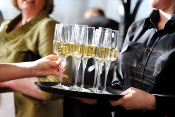 Waitress holding a dish of champagne and wine glasses