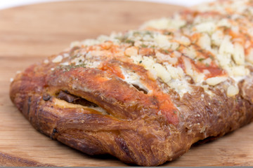 Pizza sandwich on wooden board over white