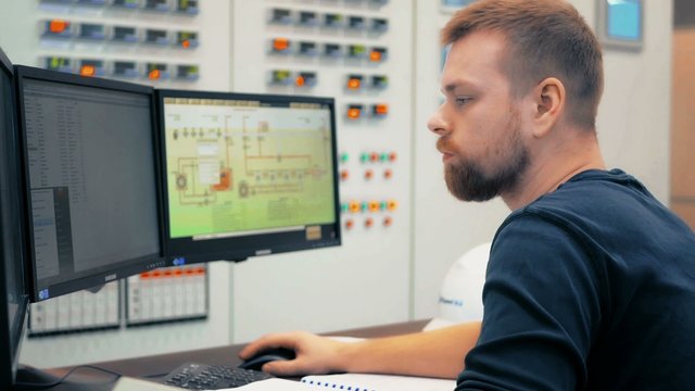 engineer computer controls the operation of machinery in the modern factory