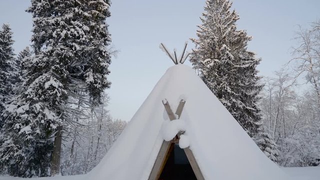 The labrador retriever inside the teepee house with the snowy road outside during the winter season in Estonia