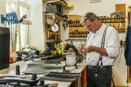 Saddler adjusting buckles for leather rucksack