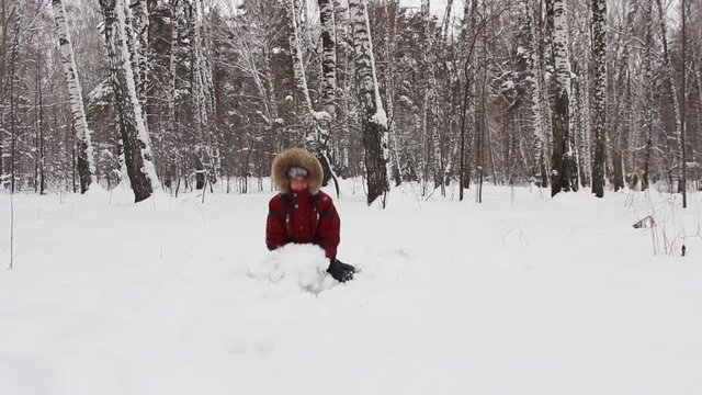 The child plays in winter forest