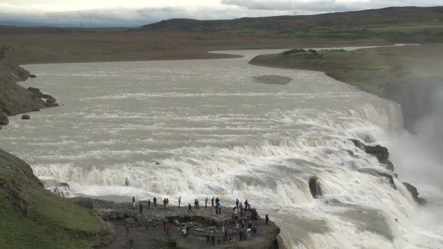 Tourists visiting Gulfoss waterfall in Iceland, part of the Golden Circle tour route.