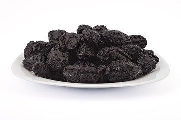 Raw organic prunes, dried plums, on the plate isolated on a white background