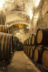 Wine barrels stacked in the old cellar of the winery