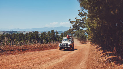 Naklejka premium Car driving on country road with canoe on top