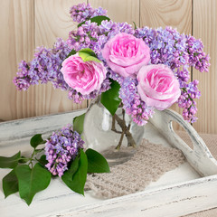 Lilac flowers and roses on shabby wooden salver
