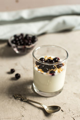 Glass 0f yogurt with muesli and black currants