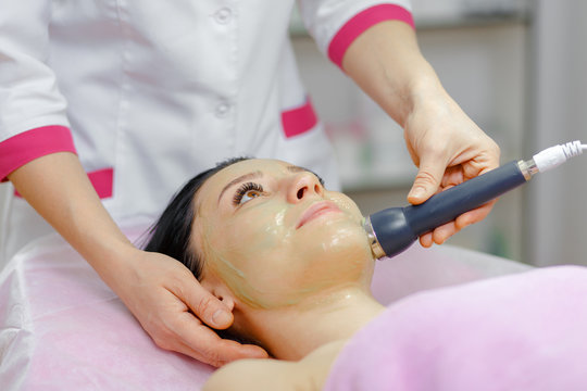 Young beautiful woman with dark hair gets procedure in the beauty salon