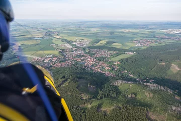 Fototapeten Anflug auf Ilsenburg(Harz) aufgenommen aus einem Flugschrauber, der Blick geht über den Buchberg auf Ilsenburg. Rechts zieht sich der Ort in das Ilsetal hinein, im Hintergrund das Harzvorland. © dmaphoto