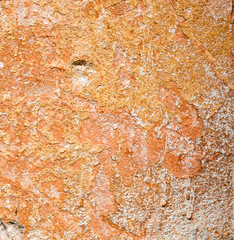 Concrete surface with the remains of orange paint and whitewash