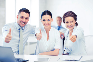 business team showing thumbs up in office