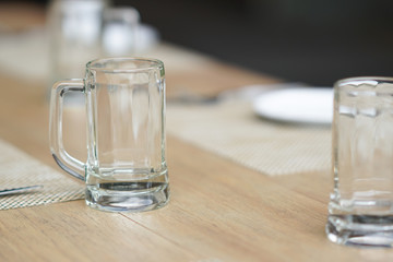 empty glass mug, cutlery and white dish
