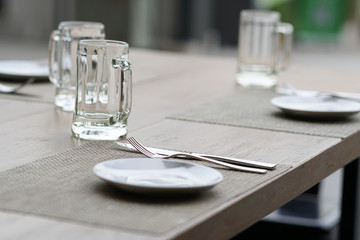 empty glass mug, cutlery and white dish