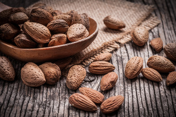 Tasty almond nuts on rustic wooden background