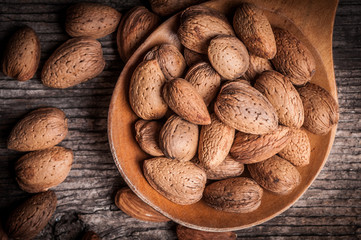 Tasty almond nuts on rustic wooden background