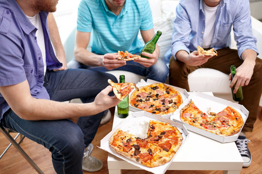 Close Up Of Friends With Beer And Pizza At Home