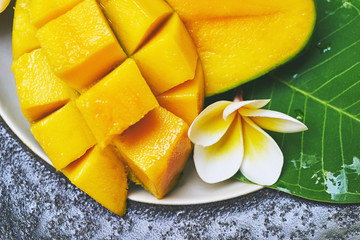 Fresh mango on a wooden tabel with tropical background. Soft focus.