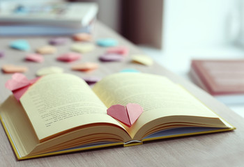 Books and heart shaped bookmarks on a wooden table