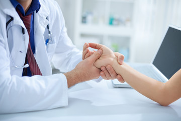 Obraz na płótnie Canvas Doctor holding patient’s hand