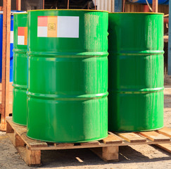 Green barrels with label on wooden pallets