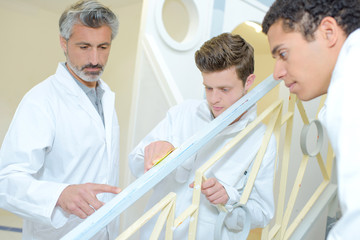 Fototapeta premium Apprentices preparing surface to repaint