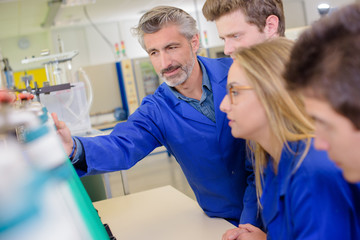 Teacher with students, wearing blue jackets