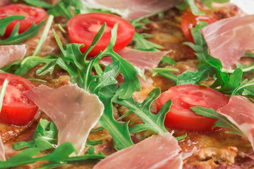 Pizza with Porsciutto, cherry tomatoes and rocket salad