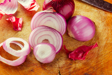 selective focus to slice purple onion on wood board.