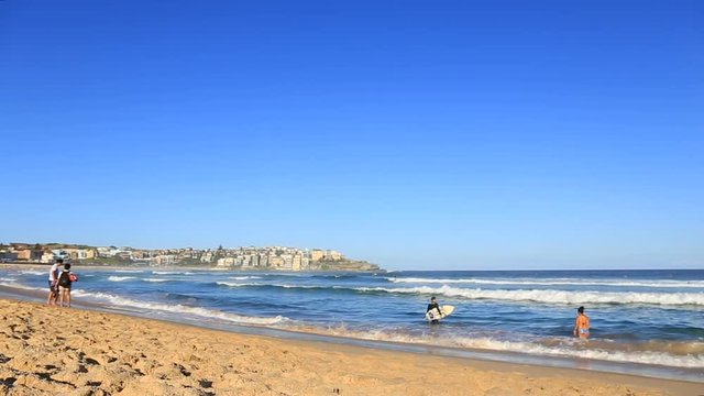 Big beautiful turquoise waves breaking on a sandy beach and people swimming in the ocean at a beach in Australia a good clear weather