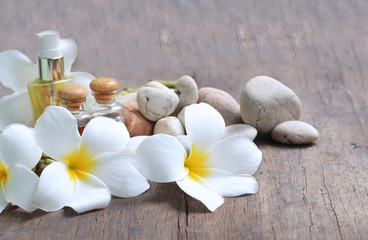 Fototapeta na wymiar Plumeria flowers with aroma oils on wooden blur background