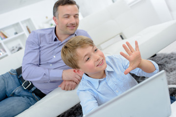 Child on computer holding up five fingers