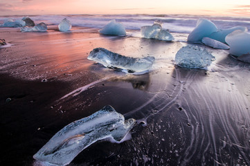 Ice on the black volcanic beach near Jokulsarlon glacier lagoon, winter Iceland - obrazy, fototapety, plakaty