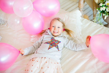 Fototapeta premium little girl playing with pink balloons
