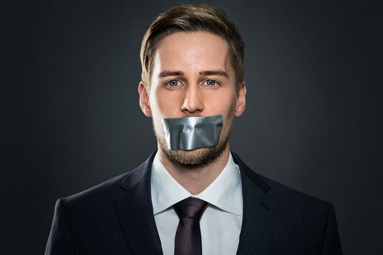 Businessman with tape on his mouth