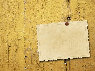 Close-up of one blank brown old vintage postcard frame with pin on ochre weathered wooden boards...