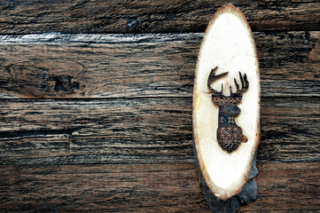 Wooden deer on wooden plank on wooden background