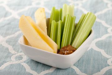 Celery and apple sticks on a blue and white place mat
