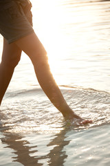 jambes de femme qui marchent dans le sable à la plage le soir