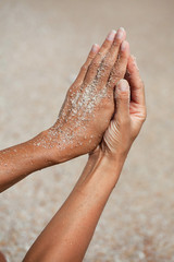 gros plan de mains de femme avec du sable